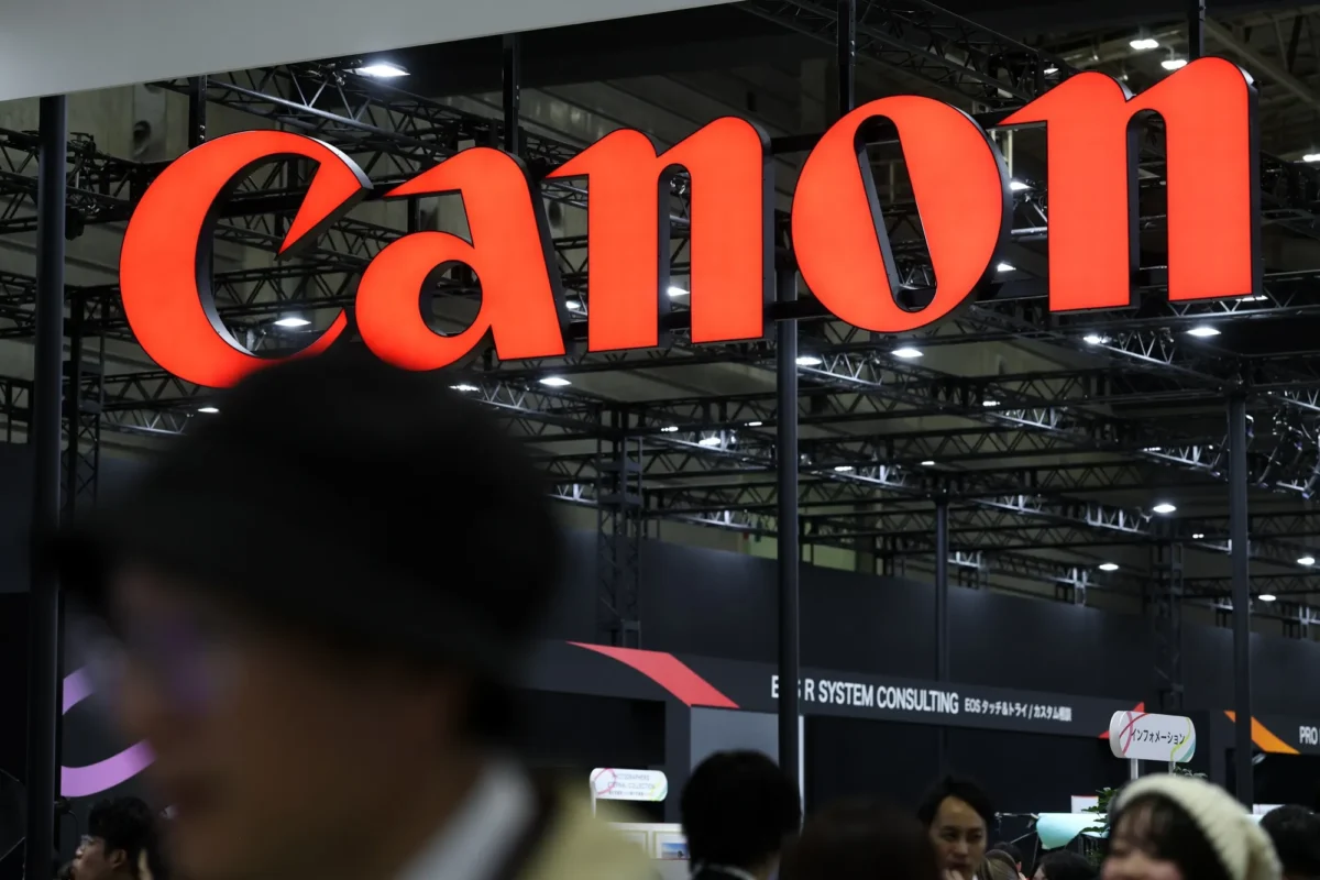 تابلوی بزرگ قرمزرنگ Canon در غرفهای نمایشگاهی، بالای سر بازدیدکنندگان دیده میشود