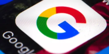 نمای نزدیک و باکیفیت از اپلیکیشن یا نماد گوگل (Google) با رنگهای چهارگانه مشخص روی صفحه نمایشگر و متن «Google» در کنار آن.