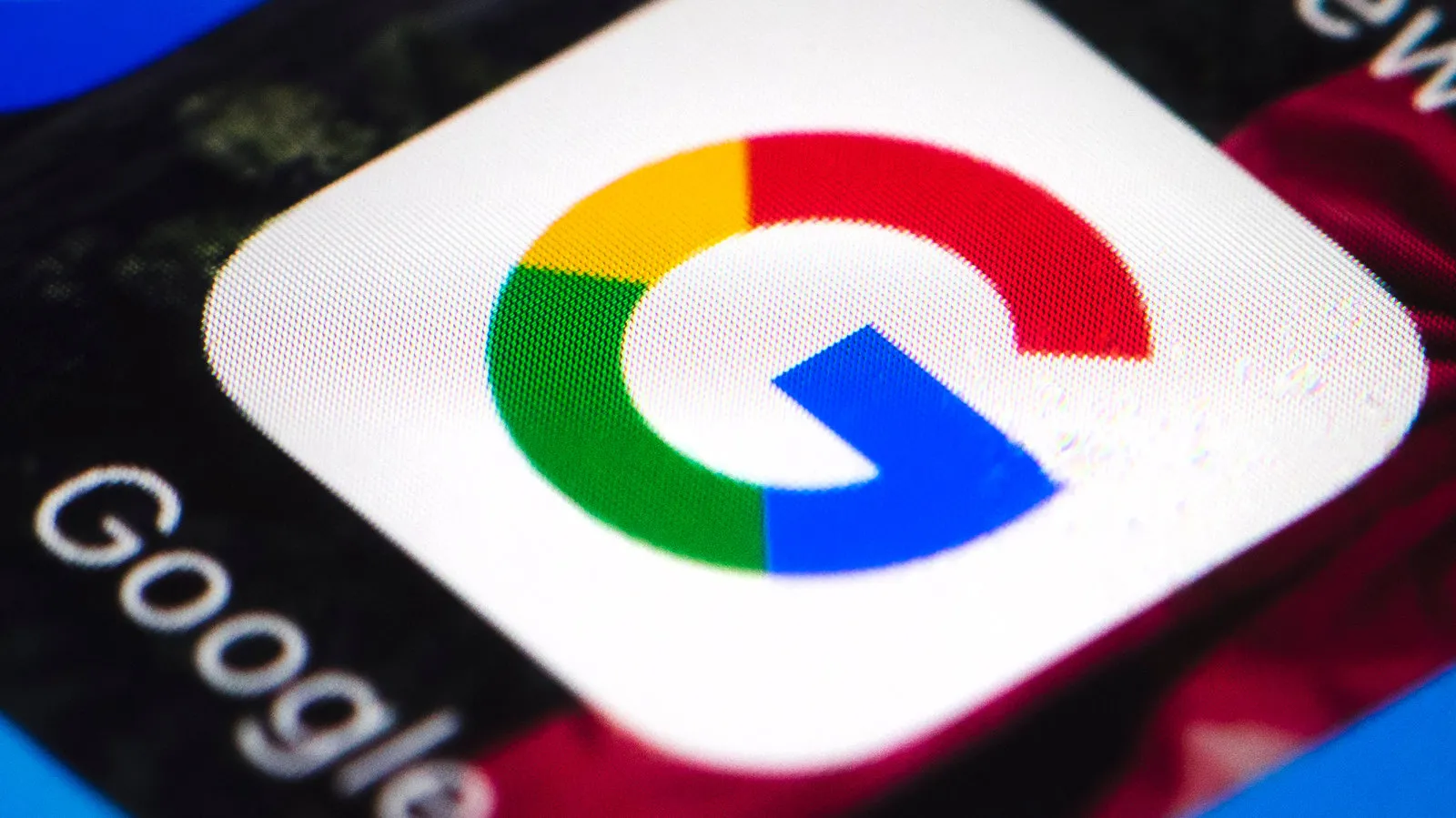 نمای نزدیک و باکیفیت از اپلیکیشن یا نماد گوگل (Google) با رنگهای چهارگانه مشخص روی صفحه نمایشگر و متن «Google» در کنار آن.