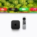 دستگاه Apple TV مشکیرنگ و ریموت کنترل آن روی سطحی سفید در کنار بخشی از تلویزیون که رابط کاربری tvOS و آیکون برنامههای مختلف را نشان میدهد.