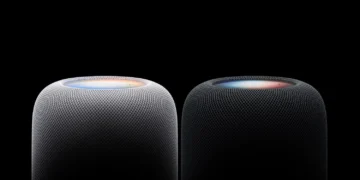 نمای نزدیک از بخش بالایی دو اسپیکر هوشمند HomePod اپل در رنگهای سفید و مشکی با پوشش پارچهای مشبک و سطح لمسی نورانی رنگی در پسزمینه کاملاً سیاه.