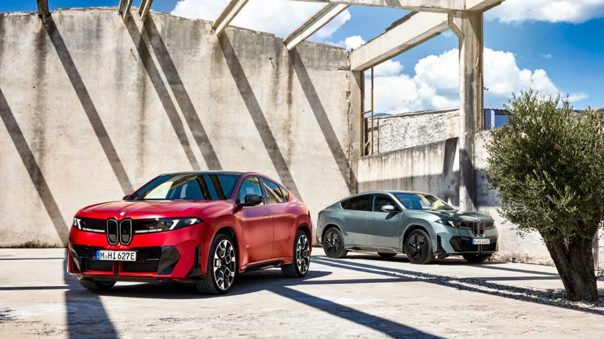 نمایش دو نسخه BMW iX4 قرمز و نقرهای در کنار دریا، با نمای سهرخ جلو و عقب، سقف شیبدار و طراحی آیرودینامیک بدنه