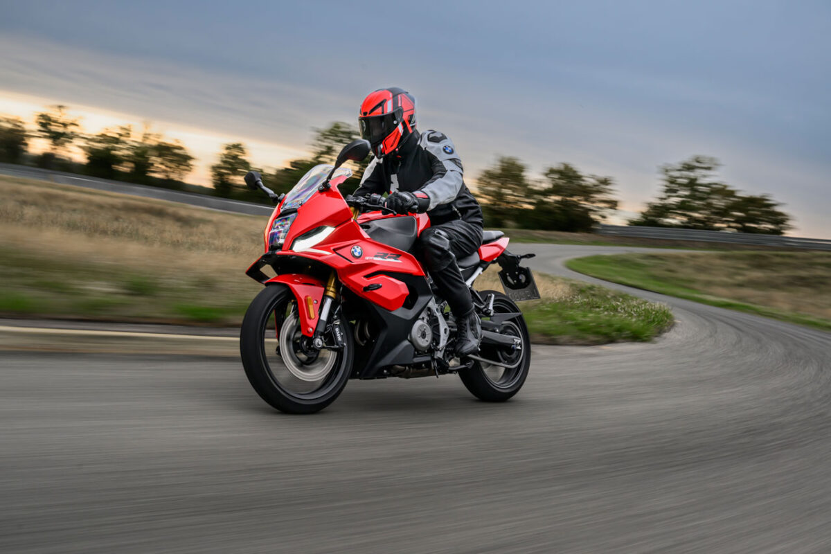 موتورسیکلت اسپرت قرمز BMW F 450 RR با طراحی آیرودینامیکی و چراغهای LED در حال حرکت در پیست مسابقه