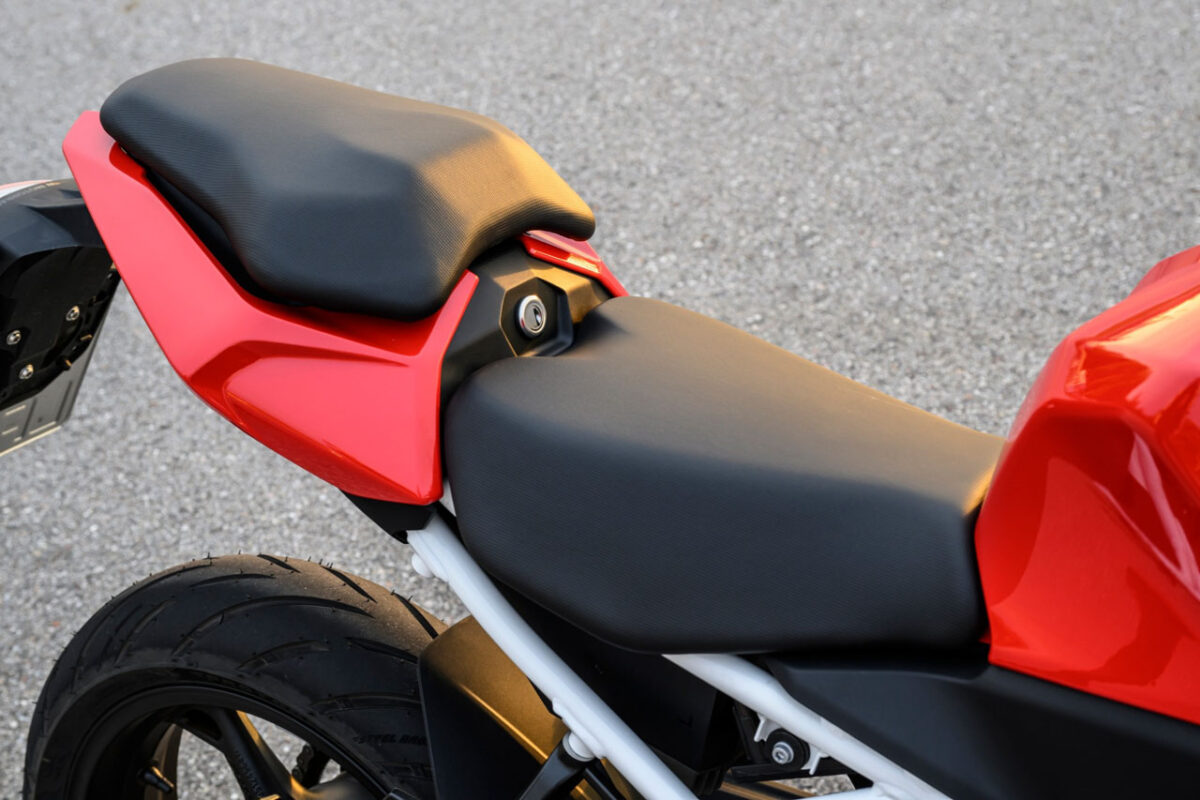 نمای نزدیک زین دوبخشی مشکی موتورسیکلت BMW F 450 RR با طراحی اسپرت و بدنه قرمز در قسمت عقب