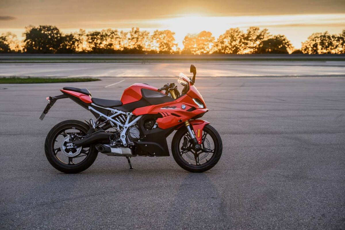 نمای جانبی موتورسیکلت BMW F 450 RR با بدنه قرمز، شاسی فولادی و طراحی اسپرت در هنگام غروب خورشید