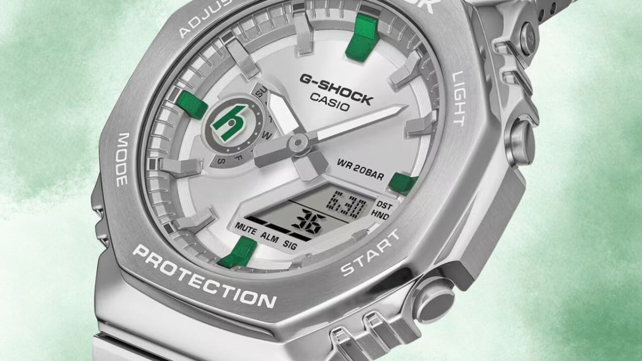 نمای نزدیک و تبلیغاتی از ساعت کاسیو جی‌شاک نقره‌ای با پس‌زمینه‌ی سبز ملایم و جزئیات طراحی صفحه.