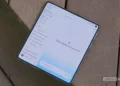 یک گوشی هوشمند تاشو (Foldable) باز شده روی سطح چوبی قرار دارد که رابط کاربری اپلیکیشن جمینای شامل منوی کناری یادداشتها و عبارت «What should we focus on?» را نمایش میدهد