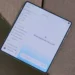 یک گوشی هوشمند تاشو (Foldable) باز شده روی سطح چوبی قرار دارد که رابط کاربری اپلیکیشن جمینای شامل منوی کناری یادداشت‌ها و عبارت «What should we focus on?» را نمایش می‌دهد