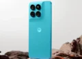 گوشی فیروزه‌ای موتورولا Moto G47 Power ایستاده روی سنگ در نمای پشت با دوربین چهارگانه و لوگوی موتورولا.