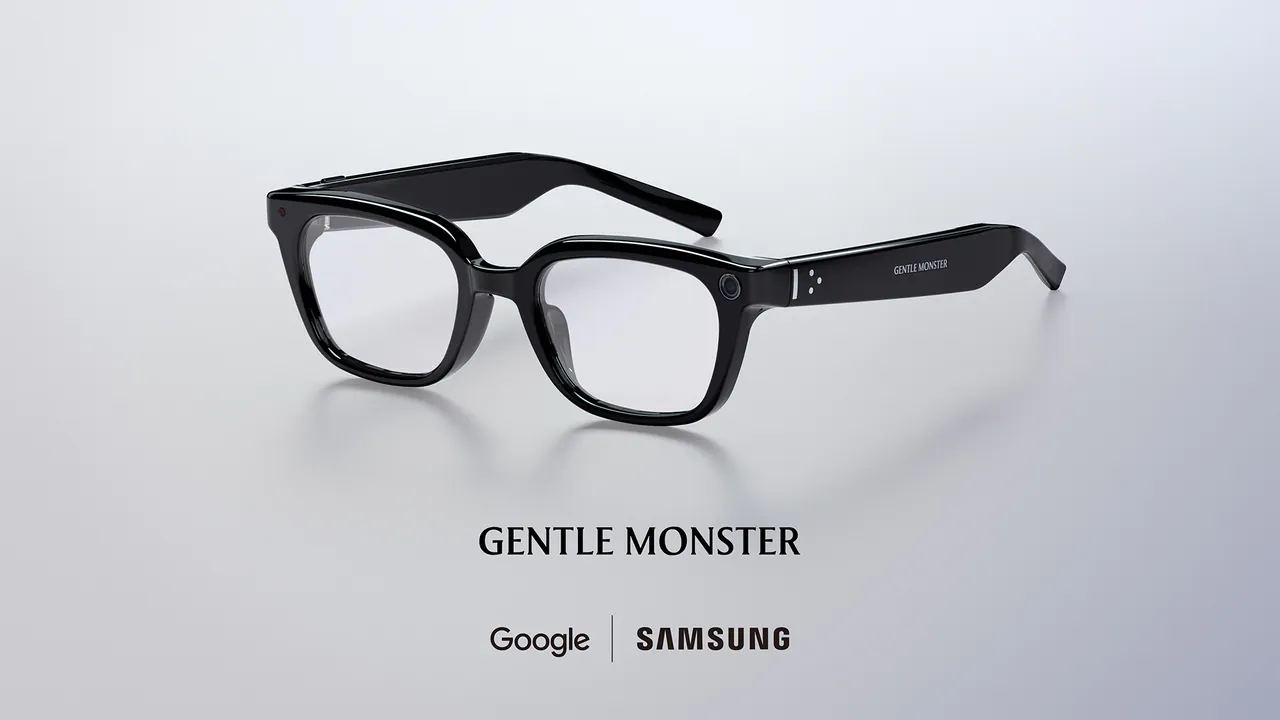 عینک هوشمند مشکی رنگ با دوربین روی دسته، بالای نوشته Gentle Monster و همکاری مشترک Google و Samsung روی پسزمینه خاکستری روشن.