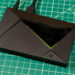 تی‌وی باکس Nvidia Shield TV Pro با بدنه مشکی، طراحی زاویه‌دار و خط نورانی سبز روی صفحه کار مدرج سبز