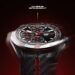 نمای نزدیک ساعت هوشمند TAG Heuer Connected Calibre E5 با عقربهها و نشانگرهای قرمز مسابقهای، قاب سرامیکی و بند با بافت فیبر کربن و دوخت قرمز، روی پسزمینهای با تم تیره و قرمز حرکت دورانی دارد.