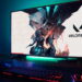 مانیتور گیمینگ با پسزمینهی بازی Valorant و نورپردازی RGB در لبهی پایینی، قرارگرفته روی میز در کنار کیبورد و موس مکانیکی با نور پسزمینهی قرمز و هدفون گیمینگ