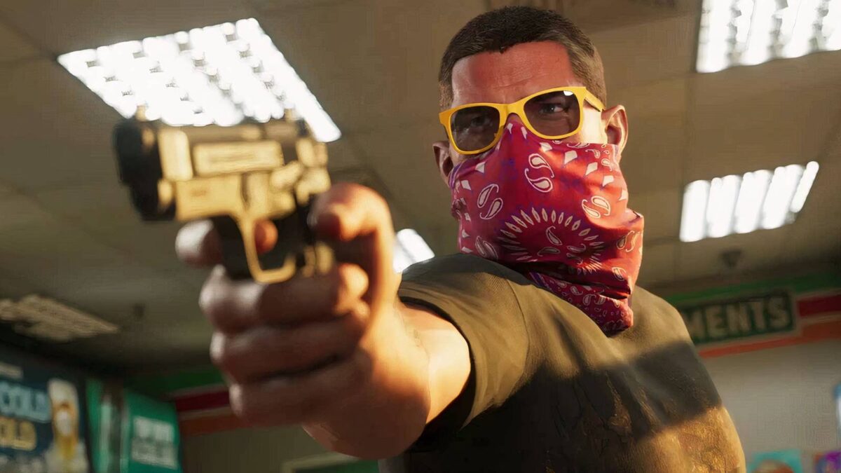 اسکرینشات سینمایی از بازی GTA VI: شخصیت جیسون با تیشرت مشکی، عینک آفتابی فریم زرد با شیشههای دودی و دستمال سر قرمز طرحدار (باندانا) که نیمهی پایینی صورتش را پوشانده، اسلحه کمری مشکیرنگی را به سمت دوربین نشانه رفته است. نمای کلوزآپ با فوکوس عمیق روی چهره و دست، در فضای روشن یک فروشگاه با سقف کاذب و چراغهای مهتابی فلورسنت ثبت شده است.