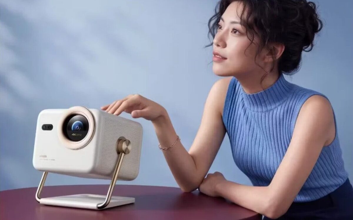 تصویری از پروژکتور Vidda Big Eye M2 Pro و کاربری که در حال کار با آن است