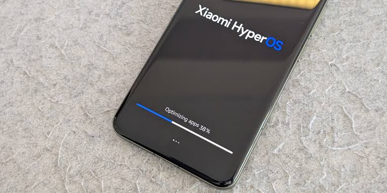 نمای نزدیک از نمایشگر یک گوشی شیائومی با سیستم‌عامل Xiaomi HyperOS در حال بهینه‌سازی اپلیکیشن‌ها و نوار درصد پیشرفت.