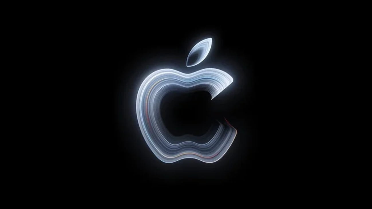 لوگوی درخشان Apple با خطوط چندلایهی سفید و رنگی در مرکز پسزمینهی سیاه.