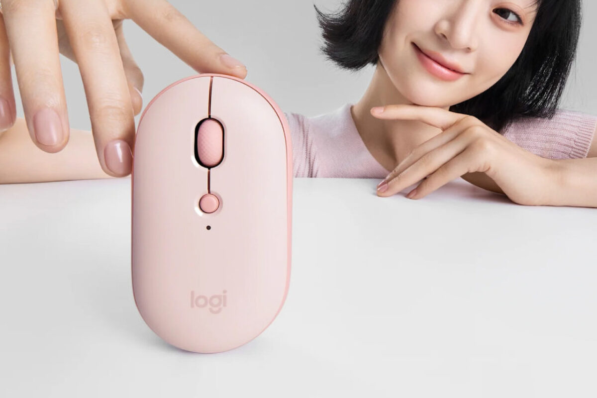 ماوس صورتی Logitech Pebble Up با طراحی باریک و دکمه تنظیم DPI در کنار کاربری که انگشت خود را روی آن قرار داده است 