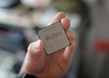 نمای نزدیک از دستی که پردازنده AMD Ryzen 7 5800X3D را نگه داشته است.