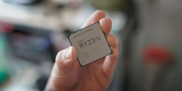 نمای نزدیک از دستی که پردازنده AMD Ryzen 7 5800X3D را نگه داشته است.
