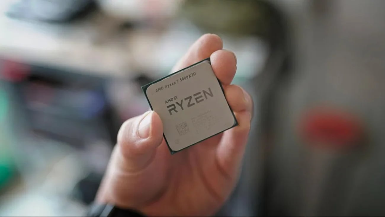 نمای نزدیک از دستی که پردازنده AMD Ryzen 7 5800X3D را نگه داشته است.